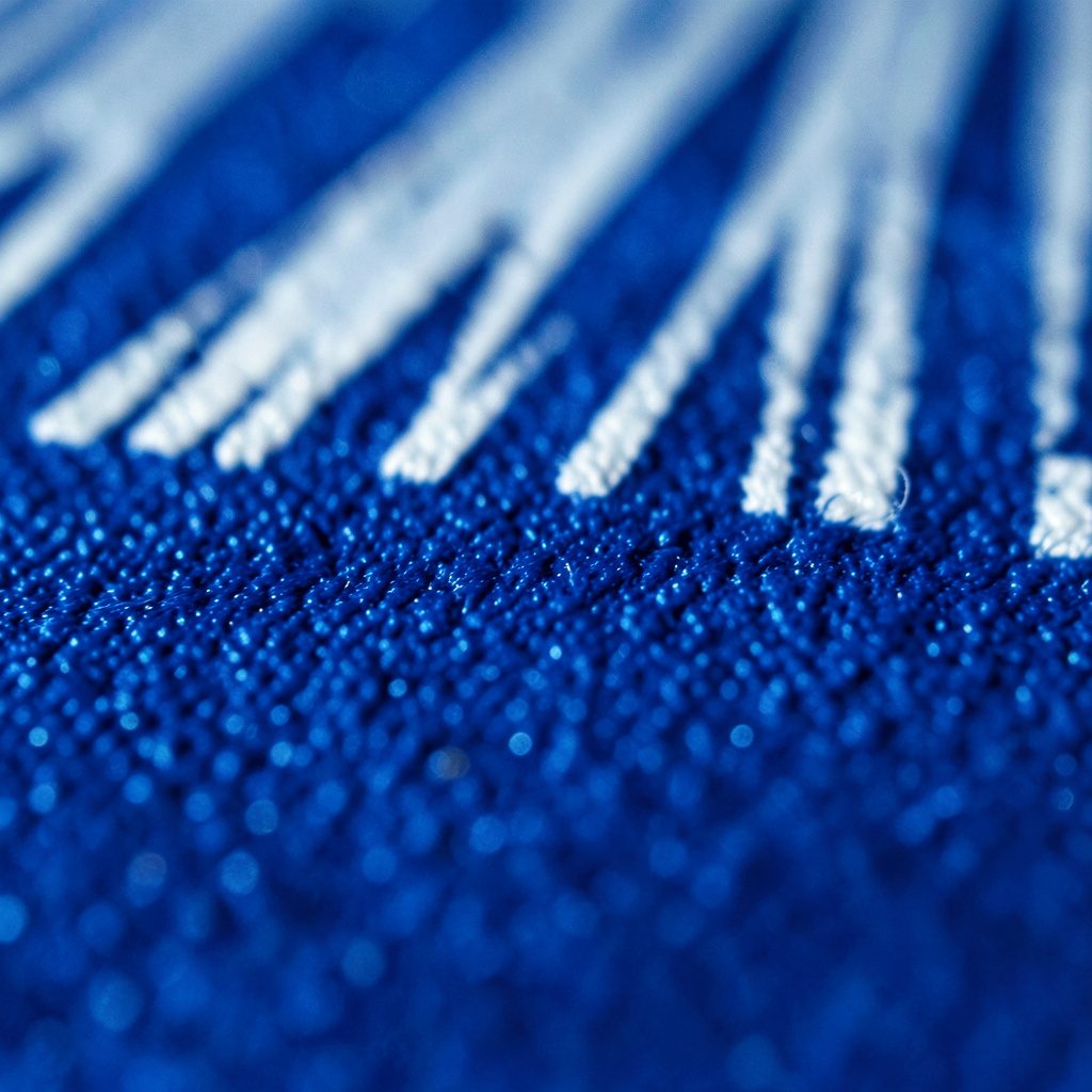 Extreme close-up of black oxide-coated steel with a uniform dark finish, subtle oil sheen across the surface